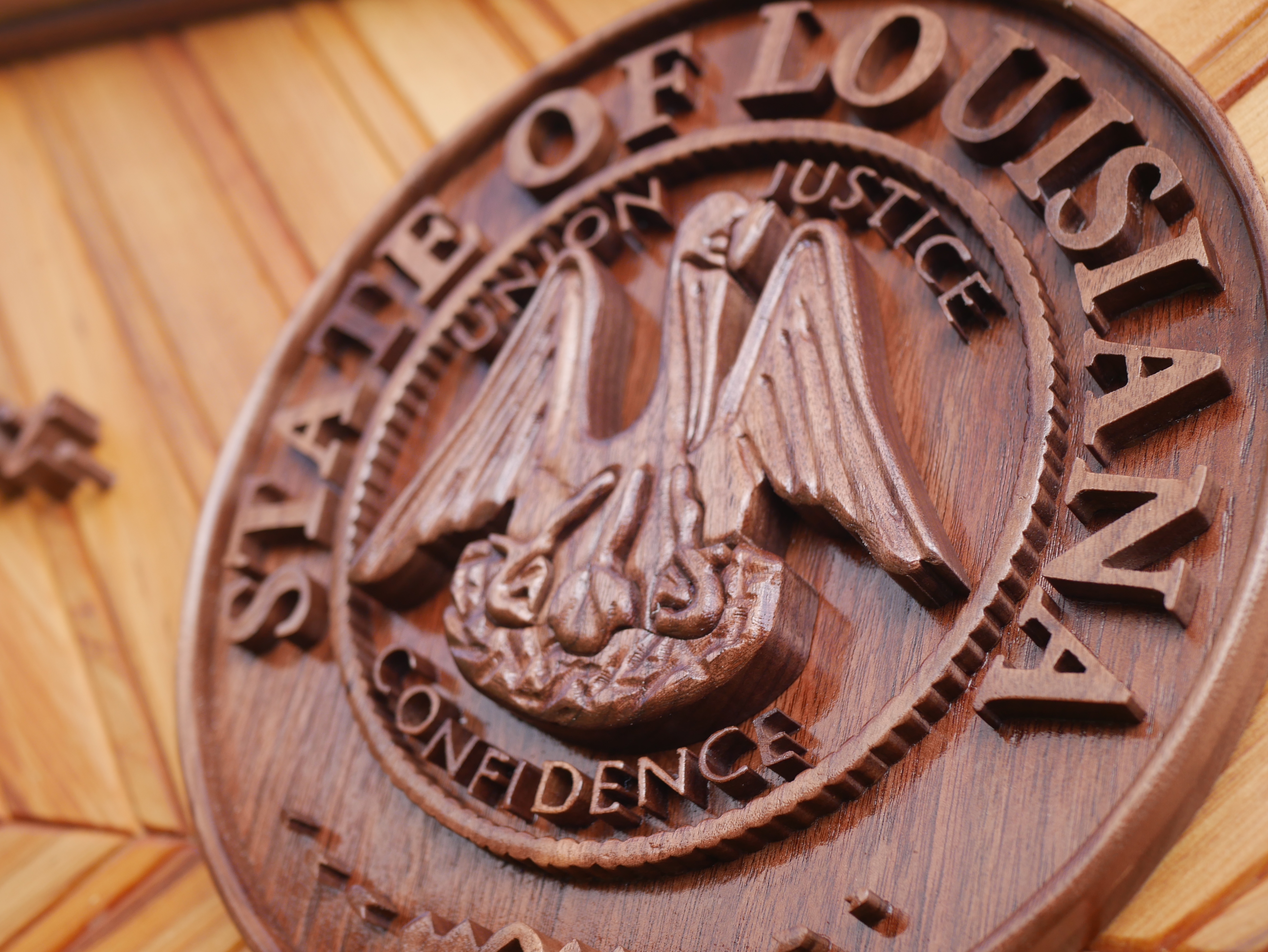 Close-up detail of custom wood business sign with raised lettering and seal